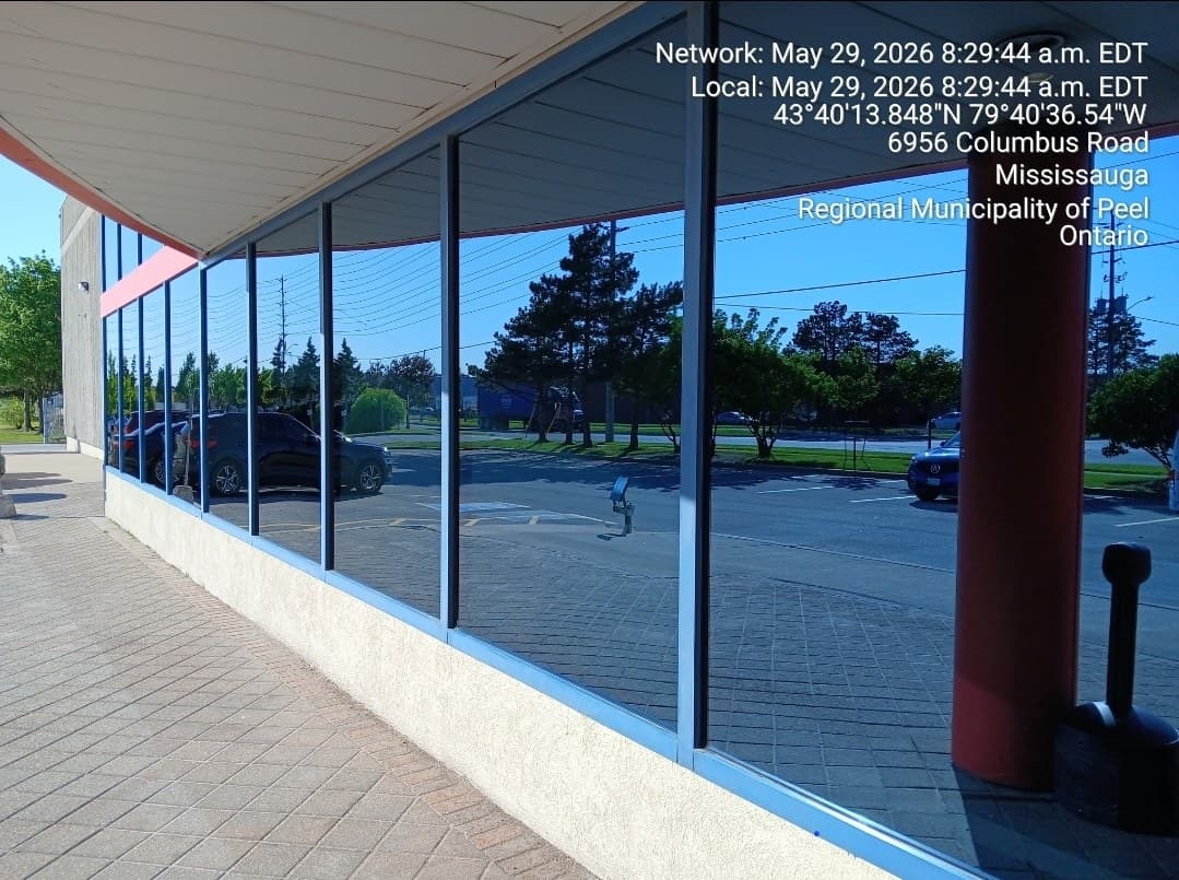 Storefront glass panels reflecting a clear blue sky